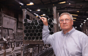 Steve James, managing director at Alfiniti, stands in front of 6061-T8 tubes.